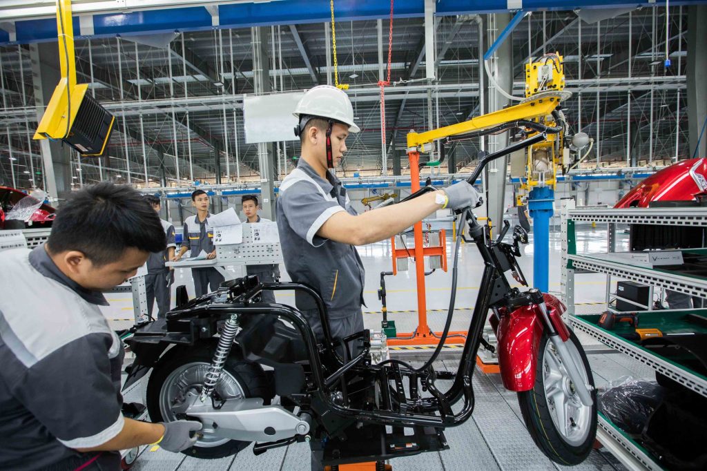 Kỹ thuật viên Vinfast mặc áo bảo hộ lắp ráp xe điện